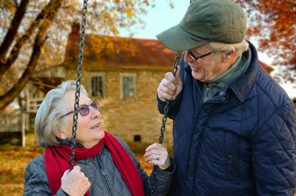 Older couple at an outdoor swing in fall